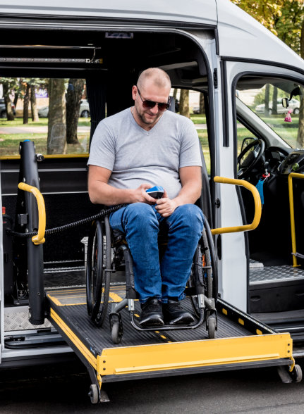 man in wheelchair smiling while using the walkie talkie