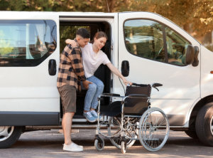 Man helping his handicapped wife to get out of van