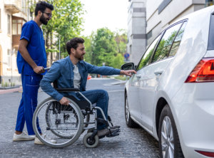 Man in a wheelchair opening a car door