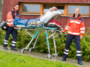 Paramedics with patient on emergency stretcher ambulance aid women man