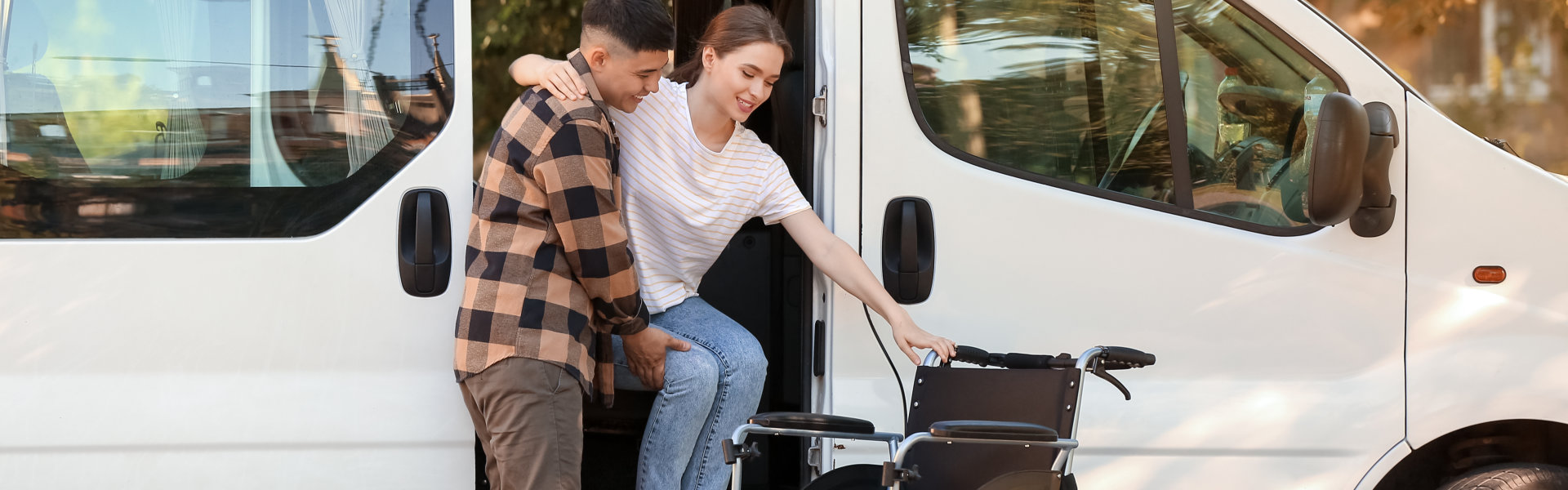 Man helping his handicapped wife to get out of van