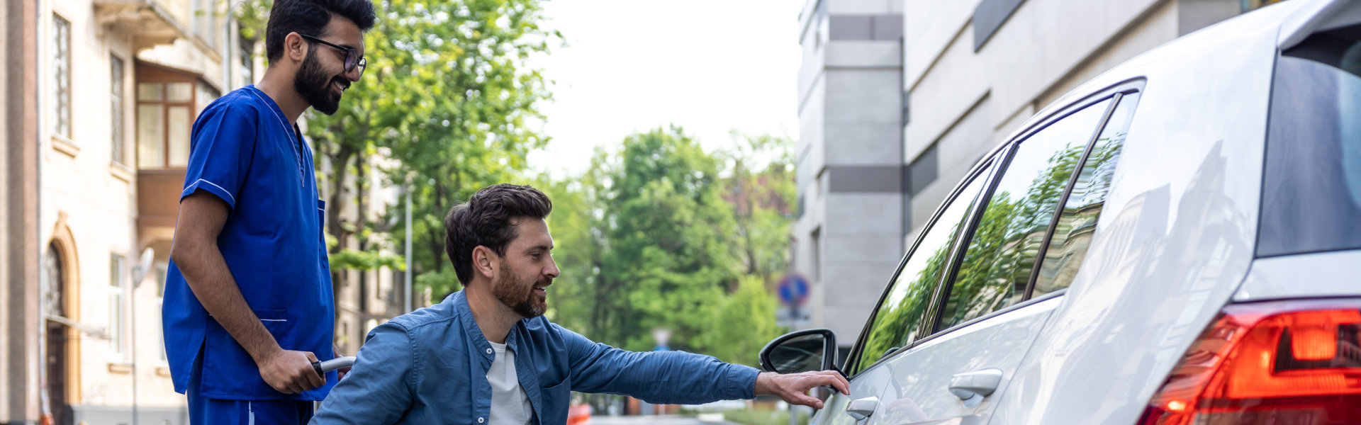 Man in a wheelchair opening a car door